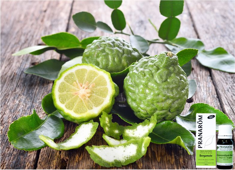 fruit de bergamote avec en petit l'emballage et la bouteille d'huile essentielle