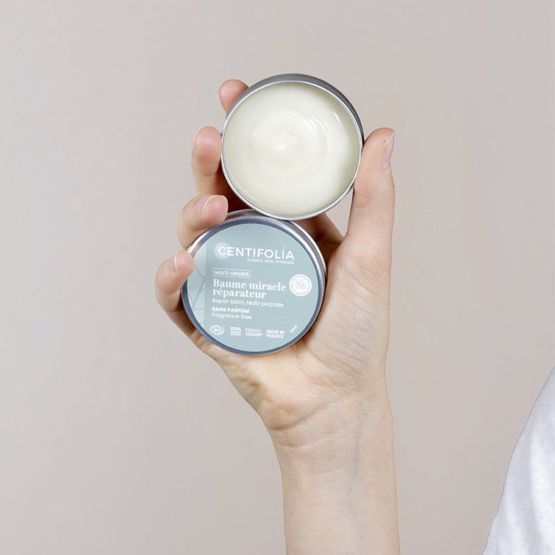 BAUME MULTI-USAGES DE MARQUE CENTIFOLIA SANS PARFUM EMBALLAGE OUVERT PRÉSENTÉ DANS UNE MAIN
