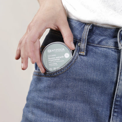 BAUME MULTI-USAGES DE MARQUE CENTIFOLIA SANS PARFUM EMBALLAGE FERMÉ EN TRAIN D'ÊTRE MIS DANS UNE POCHE DE JEANS