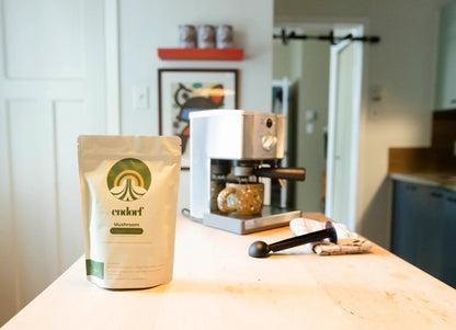 EMBALLAGE DES GRAINS DE CAFÉ INFUSÉS AUX CHAMPIGNONS AVEC MACHINE EN ARRIÈRE PLAN