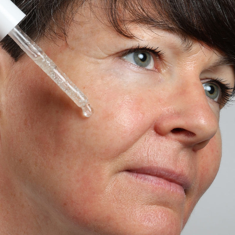 APPLICATION DU SÉRUM PERLÉ TRIPLE ACTION DE LA COLLECTION LYS ACTIVE DE LA MARQUE CENTIFOLIA SUR LE VISAGE D'UNE DAME
